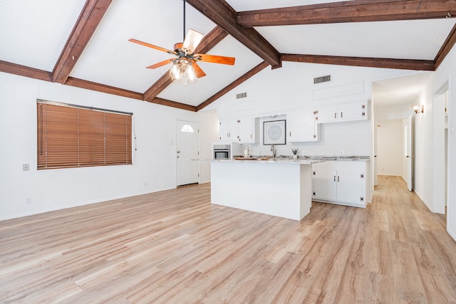 164 Harbor Dr, Gun Barrel City, TX 75156 - kitchen featuring ceiling fan, light countertops, light wood-type flooring, white cabinets, and beamed ceiling