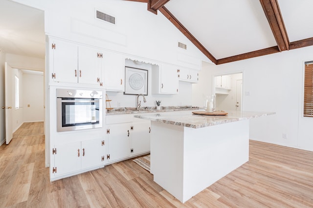 164 Harbor Dr, Gun Barrel City, TX 75156 - kitchen featuring oven, a sink, a center island, white cabinets, and beam ceiling