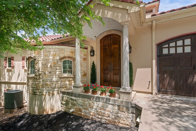 2510 River Ridge Court, Granbury, TX 76048 - entrance to property featuring a tile roof, cooling unit, stucco siding, and stone siding