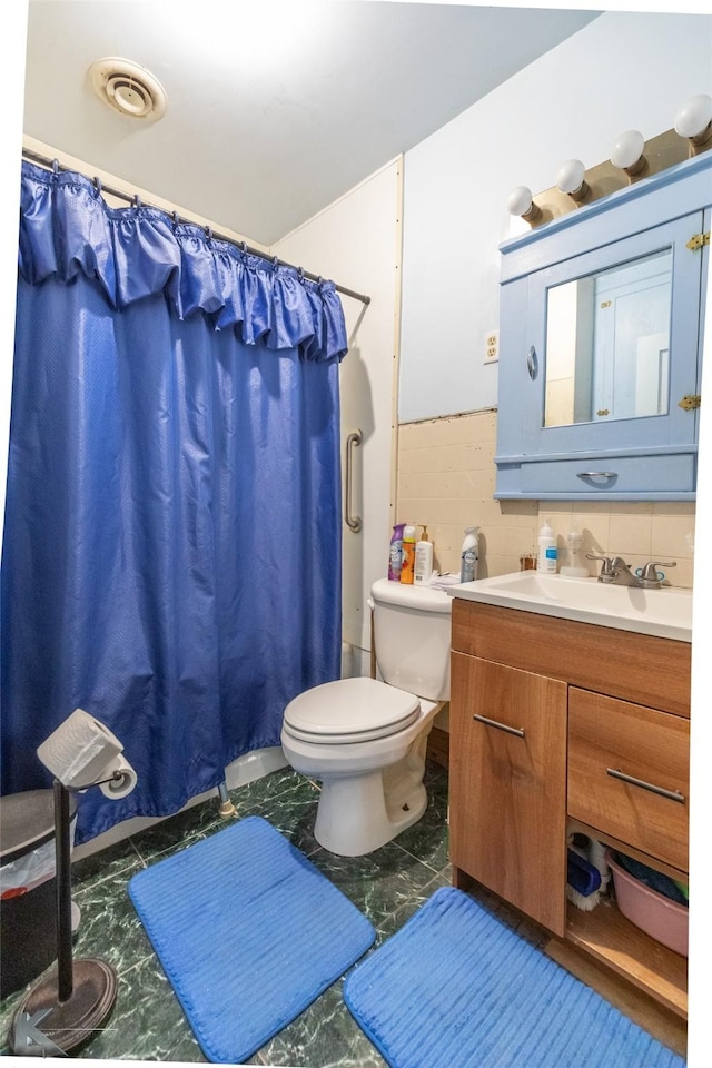 1541 S 9th St, Abilene, TX 79602 - bathroom with marble finish floors, toilet, vanity, and curtained shower