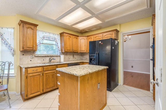 2816 Wateridge Ct, Grapevine, TX 76051 - kitchen with black fridge, a sink, light tile patterned flooring, a kitchen island, and tasteful backsplash