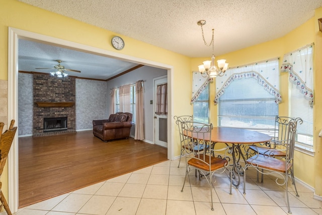 2816 Wateridge Ct, Grapevine, TX 76051 - dining area featuring plenty of natural light, ceiling fan, a fireplace, a textured ceiling, and a chandelier