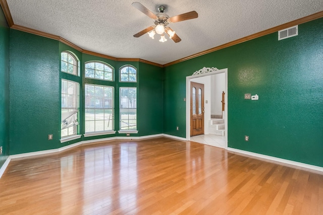 2816 Wateridge Ct, Grapevine, TX 76051 - empty room featuring a textured ceiling, wood finished floors, ornamental molding, ceiling fan, and a textured wall