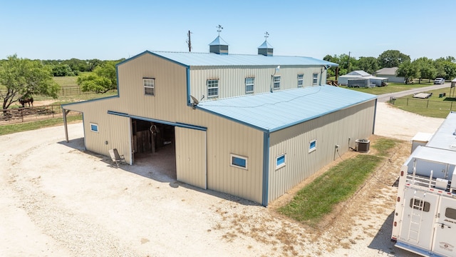 200 County Road 129, Stephenville, TX 76401 - rear view of house featuring a pole building, central AC unit, a detached garage, an outbuilding, and driveway