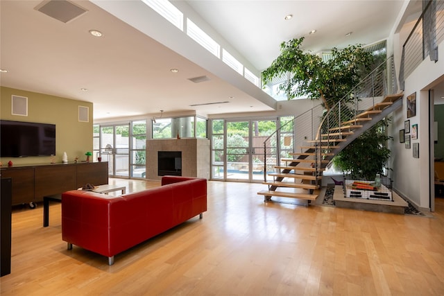 10611 Royal Springs Dr, Dallas, TX 75229 - living area with stairs, light wood finished floors, a tile fireplace, floor to ceiling windows, and recessed lighting