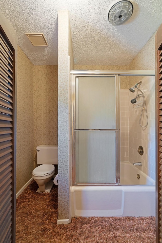 905 W 11th, Clarksville, TX 75426 - full bathroom with toilet, bath / shower combo with glass door, and a textured ceiling