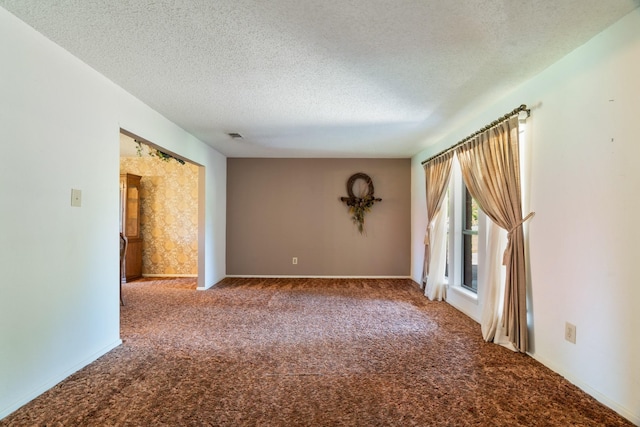 905 W 11th, Clarksville, TX 75426 - empty room featuring carpet, a textured ceiling, and baseboards