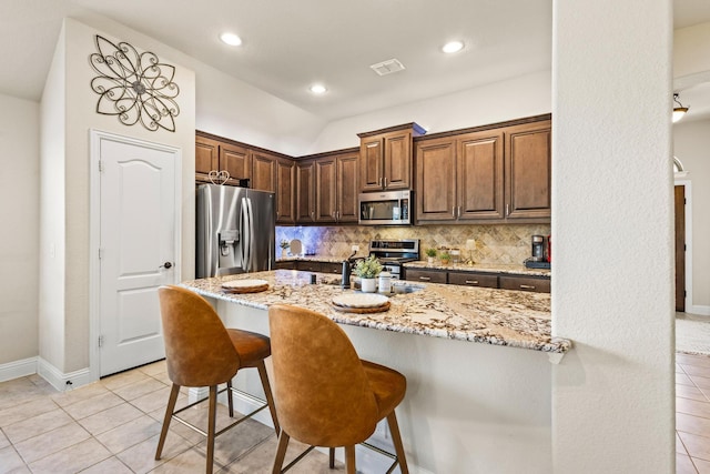403 Woodbine Dr, Sherman, TX 75092 - kitchen with appliances with stainless steel finishes, light tile patterned floors, light stone counters, backsplash, and recessed lighting