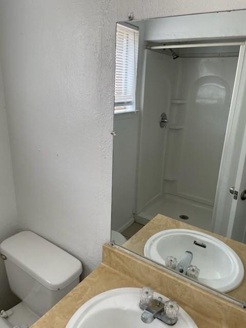 9925 Kittyhawk Ln, Dallas, TX 75217 - full bathroom with a stall shower, a sink, toilet, and a textured wall