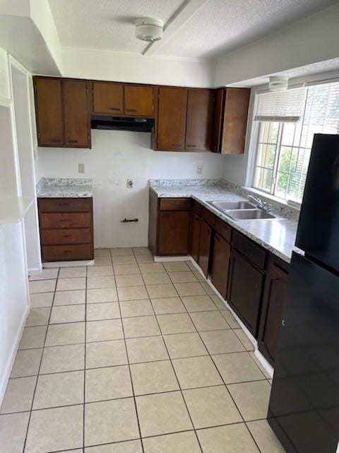 9925 Kittyhawk Ln, Dallas, TX 75217 - kitchen with a sink, freestanding refrigerator, under cabinet range hood, a textured ceiling, and light tile patterned floors