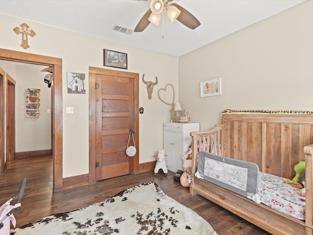 202 S Wood St, Cleburne, TX 76033 - bedroom with hardwood / wood-style floors, a nursery area, baseboards, and ceiling fan