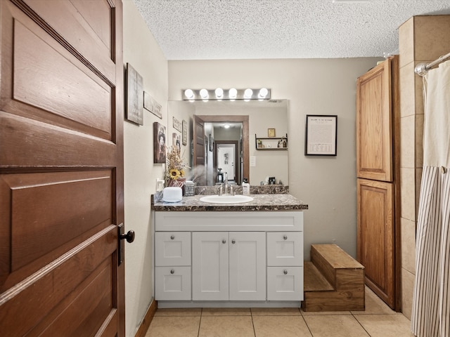 202 S Wood St, Cleburne, TX 76033 - ensuite bathroom with tile patterned flooring, vanity, and a textured ceiling