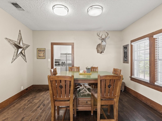 202 S Wood St, Cleburne, TX 76033 - dining space featuring dark wood finished floors, baseboards, and a textured ceiling