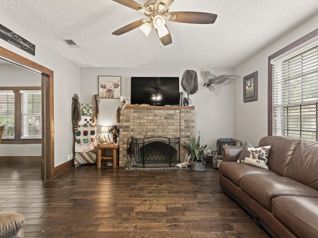 202 S Wood St, Cleburne, TX 76033 - living area with a textured ceiling, hardwood / wood-style floors, a ceiling fan, a brick fireplace, and baseboards