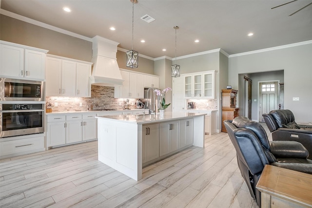 1305 Crown Valley Dr, Weatherford, TX 76087 - kitchen featuring stainless steel appliances, custom exhaust hood, open floor plan, ornamental molding, and light countertops