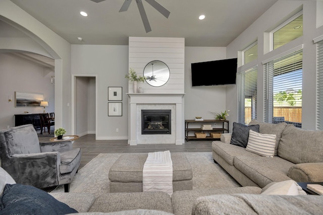1008 Myers Park Trl, Roanoke, TX 76262 - living room featuring a ceiling fan, wood finished floors, arched walkways, recessed lighting, and a fireplace