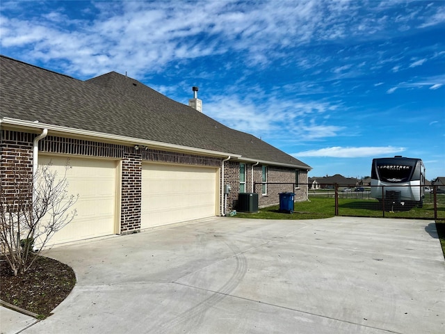 7816 Wheatland Ct, Godley, TX 76044 - view of property exterior featuring brick siding, concrete driveway, a shingled roof, a garage, and central AC unit