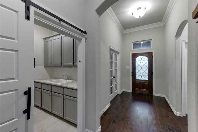 7816 Wheatland Ct, Godley, TX 76044 - foyer featuring crown molding, arched walkways, light wood-style flooring, and a barn door