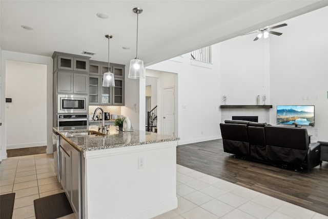 616 Evergreen Rd, Little Elm, TX 76227 - kitchen with gray cabinetry, a sink, tile patterned floors, appliances with stainless steel finishes, and ceiling fan