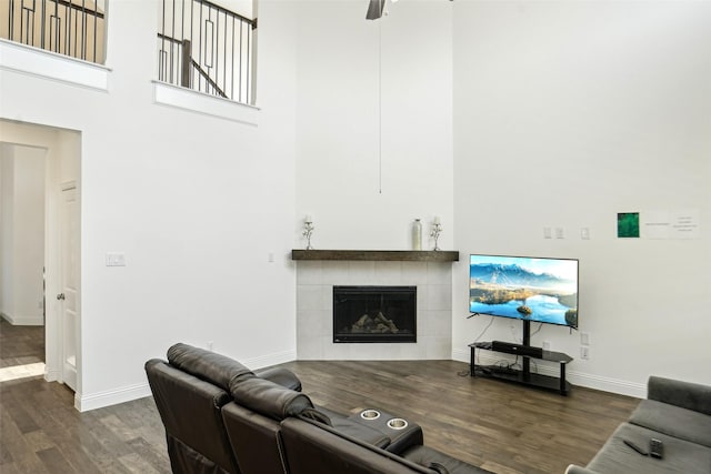616 Evergreen Rd, Little Elm, TX 76227 - living area with a high ceiling, dark wood-style floors, baseboards, a tiled fireplace, and a ceiling fan