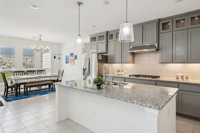 616 Evergreen Rd, Little Elm, TX 76227 - kitchen with under cabinet range hood, stainless steel appliances, gray cabinetry, backsplash, and light tile patterned floors