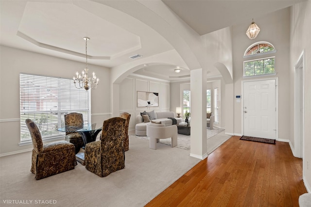 1117 Ruby St, Plano, TX 75094 - entryway with a tray ceiling, a chandelier, wood finished floors, arched walkways, and baseboards