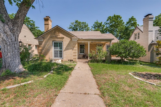 2531 W 10th St, Dallas, TX 75211 - view of front of house with brick siding, a front yard, and covered porch
