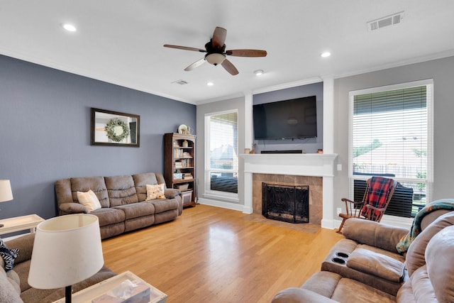 1107 Shoreview Dr, Ennis, TX 75119 - living room featuring crown molding, light wood-style flooring, a ceiling fan, a fireplace, and recessed lighting