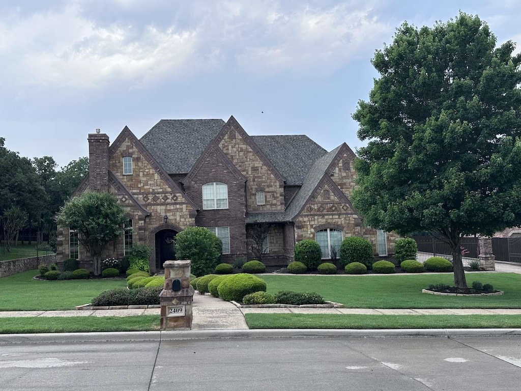 2409 Southern Hills Ct, Keller, TX 76248 - view of front of property with stone siding, a front lawn, and a chimney