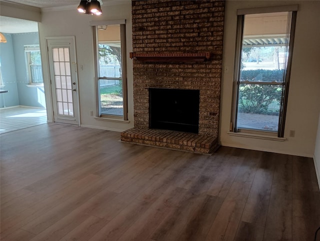 224 Crescent Dr, Hewitt, TX 76643 - unfurnished living room with wood finished floors, ornamental molding, a brick fireplace, and baseboards