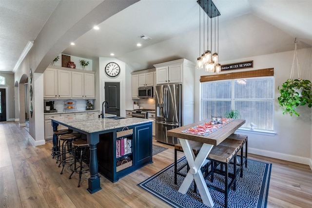 1719 Wheatberry Ln, Allen, TX 75002 - kitchen featuring stainless steel appliances, arched walkways, a sink, lofted ceiling, and a center island with sink