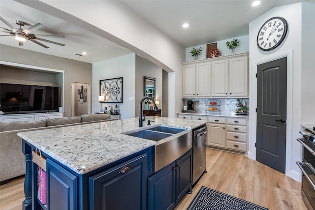 1719 Wheatberry Ln, Allen, TX 75002 - kitchen featuring blue cabinets, a sink, open floor plan, white cabinetry, and light wood-type flooring