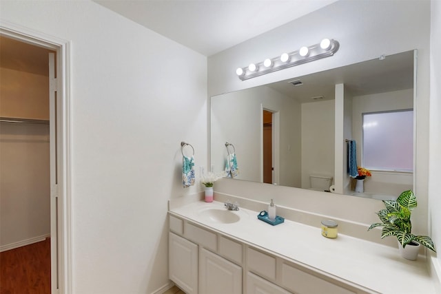 637 Stirrup Bar Dr, Fort Worth, TX 76179 - bathroom featuring vanity, baseboards, wood finished floors, toilet, and a walk in closet