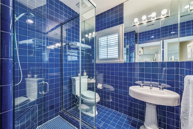 5447 Mccommas Blvd, Dallas, TX 75206 - bathroom featuring tile walls, tile patterned flooring, toilet, and a stall shower
