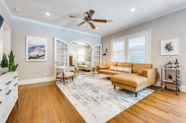 5447 Mccommas Blvd, Dallas, TX 75206 - living area with light wood-type flooring, ceiling fan, baseboards, arched walkways, and crown molding