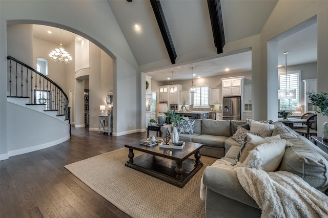 2749 Casa Grande Way, Celina, TX 75009 - living room with arched walkways, a chandelier, dark wood-style floors, stairs, and high vaulted ceiling