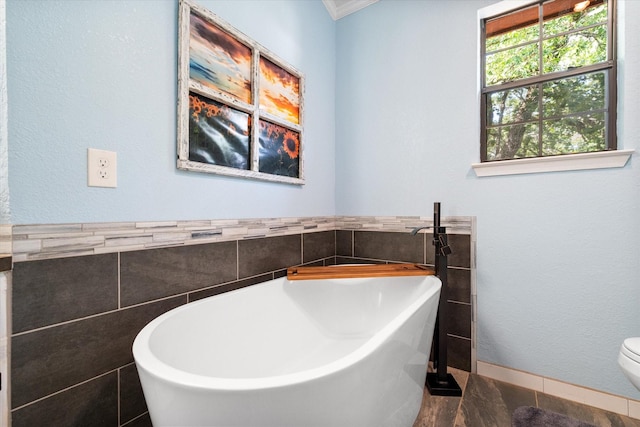 1890 Oak Valley Ln, Corsicana, TX 75110 - full bath with tile walls, a freestanding bath, toilet, and crown molding