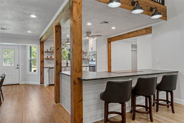 173 Cedar Ridge Dr, China Spring, TX 76633 - kitchen featuring a textured ceiling, light wood finished floors, baseboards, a ceiling fan, and appliances with stainless steel finishes