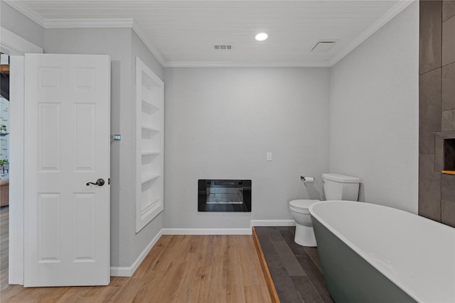 173 Cedar Ridge Dr, China Spring, TX 76633 - bathroom featuring wood finished floors, heating unit, a freestanding bath, ornamental molding, and baseboards
