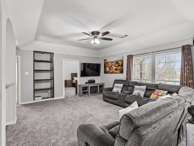 13646 Badger Creek Dr, Frisco, TX 75033 - carpeted living room with a ceiling fan, a raised ceiling, baseboards, and arched walkways