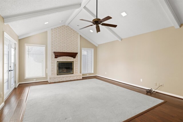 4201 Westchester Dr, Waco, TX 76710 - unfurnished living room featuring dark wood finished floors, ceiling fan, baseboards, a brick fireplace, and a textured ceiling