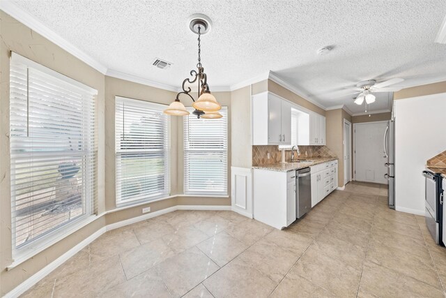 4201 Westchester Dr, Waco, TX 76710 - kitchen featuring a sink, appliances with stainless steel finishes, white cabinets, tasteful backsplash, and ornamental molding