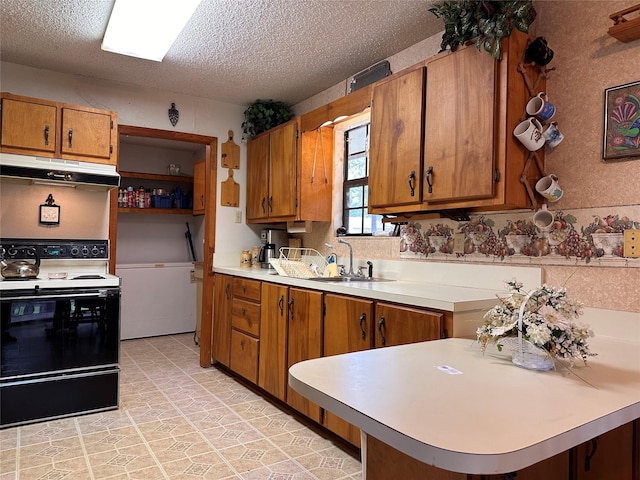 300 Hogg Creek Rd, Brownwood, TX 76801 - kitchen featuring under cabinet range hood, black range with electric cooktop, brown cabinets, light countertops, and a textured ceiling