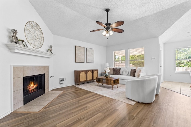 1132 Singletree Dr, Forney, TX 75126 - living area with a textured ceiling, wood finished floors, a fireplace, ceiling fan, and baseboards