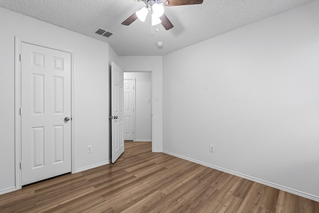 1132 Singletree Dr, Forney, TX 75126 - unfurnished bedroom with wood finished floors, a textured ceiling, baseboards, and a ceiling fan