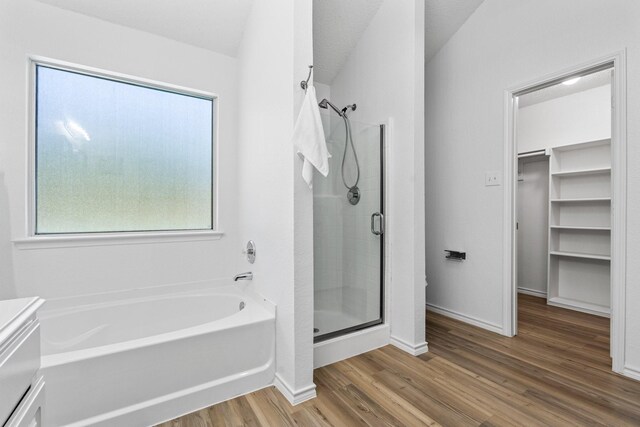 1132 Singletree Dr, Forney, TX 75126 - bathroom featuring a shower stall, wood finished floors, a garden tub, a walk in closet, and baseboards