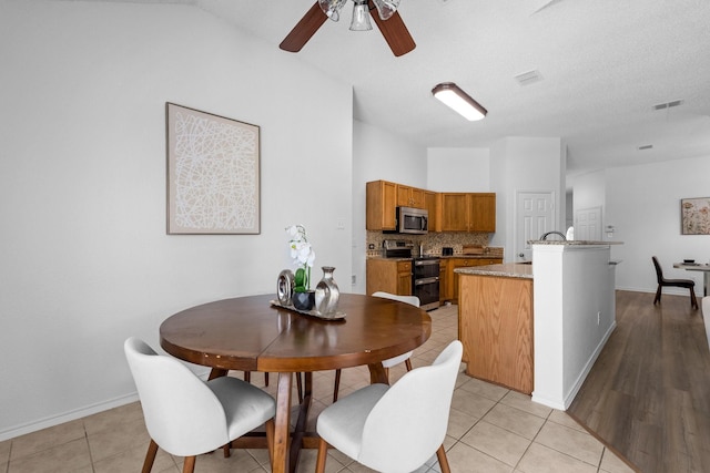 1132 Singletree Dr, Forney, TX 75126 - dining room with a ceiling fan, baseboards, light tile patterned floors, and vaulted ceiling