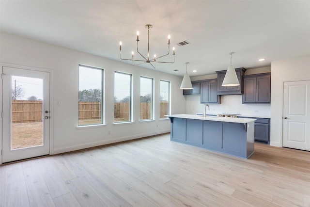 2316 Glasgow Way, Denton, TX 76207 - kitchen with a chandelier, a sink, premium range hood, backsplash, and light countertops