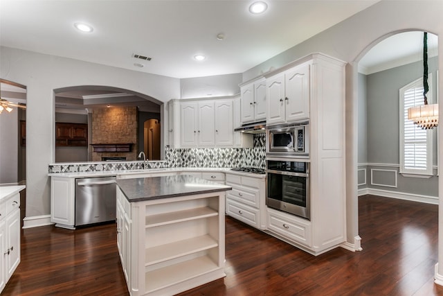 1121 Riverwalk Ct, Colleyville, TX 76034 - kitchen featuring appliances with stainless steel finishes, arched walkways, open shelves, white cabinetry, and recessed lighting