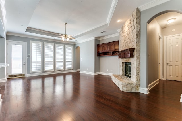 1121 Riverwalk Ct, Colleyville, TX 76034 - unfurnished living room featuring arched walkways, dark wood finished floors, a tray ceiling, a ceiling fan, and a fireplace